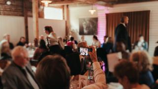 Kuvassa on tilaisuus vanhassa tallissa.