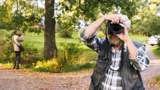 Mies on ottamassa valokuvaa. Taustalla toinen valokuvaaja.