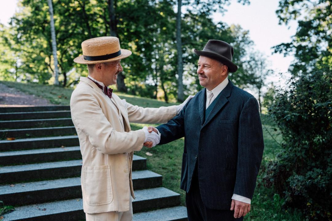 Dramatisoitu tilanne, jossa kartanonisäntä Arvid Sanmark ja pehtoori Alfred Malmgren kättelevät kartanopuistossa.